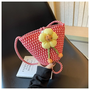 Detailed shot of red and white houndstooth woven bag with a 3D yellow floral accent