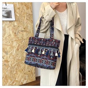 Detailed shot of ethnic tote bag featuring geometric patterns and hanging tassels