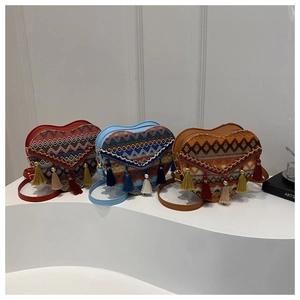 Detailed view of heart-shaped woven bags with ethnic patterns and colorful tassels