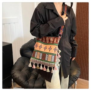 Detail view of ethnic boho tote bag with colorful tassels and geometric jacquard fabric