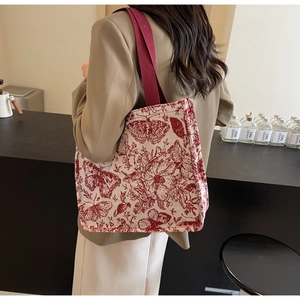 Detail of red floral butterfly jacquard knit tote bag with durable woven strap