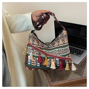 Detail of ethnic woven shoulder bag featuring colorful geometric patterns and multi-color tassels