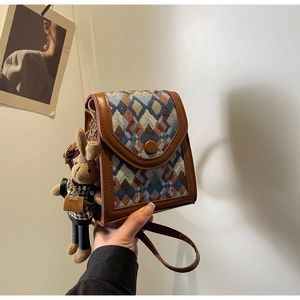 Close-up of vintage geometric jacquard crossbody bag with a cute plush rabbit charm