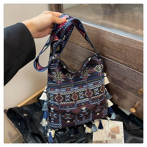 Detailed shot of Bohemian woven tote with colorful tassels and ethnic geometric patterns