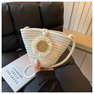 Detail of woven straw bucket bag with floral daisy decor and pearl buckle closure