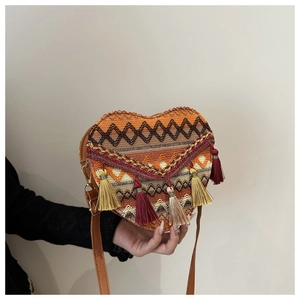 Close-up of heart-shaped woven bag with colorful geometric patterns and decorative tassels