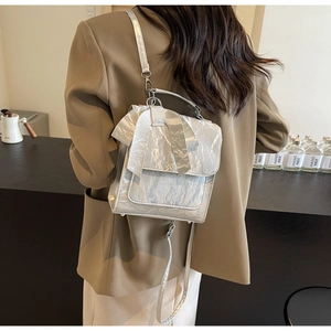 Detailed back view of a silver metallic bow backpack with a glossy wrinkled texture