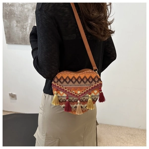 Detailed back view of a heart-shaped woven crossbody bag with colorful tassels and geometric patterns