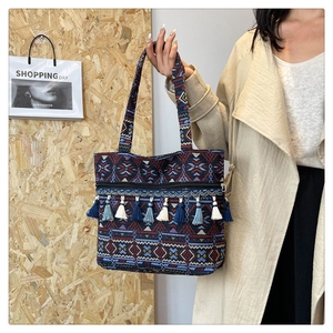 Detail of bohemian woven tote bag with vibrant geometric patterns and fringe tassels