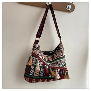 Close-up of ethnic tote bag featuring colorful woven patterns and decorative tassels