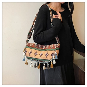 Detail of bohemian handmade woven crossbody bag with colorful tassels and jacquard strap