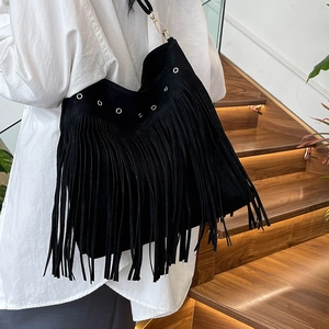 Borsa a tracolla nera con frange e occhielli d'argento indossata su una camicia bianca