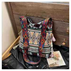 Detail of bohemian woven tote bag with colorful geometric patterns and decorative tassels