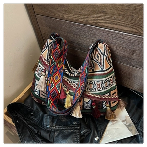 Detailed view of bohemian woven bag featuring ethnic embroidery and colorful tassels