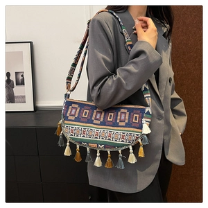 Detail of hand-woven ethnic shoulder bag with colorful tassels and patterned wide strap