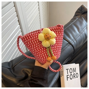 Detail of red and white checkered knit bag with a 3D yellow flower decoration