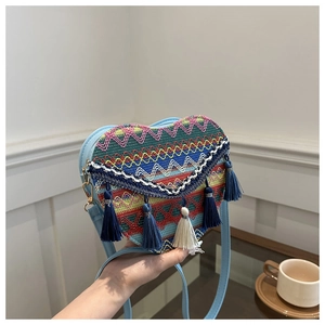 Handheld heart-shaped woven bag featuring colorful geometric patterns and long fringes