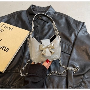 Chic silver bow mini handbag featuring metallic finish and detachable chain strap