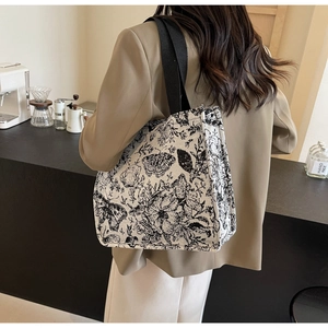 Detail of a large canvas tote bag with floral prints shown in a stylish cafe setting