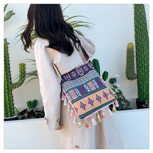 Macro detail of Bohemian tote bag featuring colorful geometric weaving and fringe