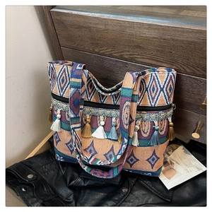 Detail of bohemian tote bag featuring colorful woven patterns and tassel decorations