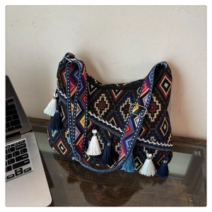 Detailed view of bohemian woven pattern and colorful fringe tassels on a shoulder bag