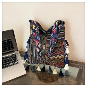 Macro detail of Bohemian tote bag featuring colorful woven patterns and layered fringe