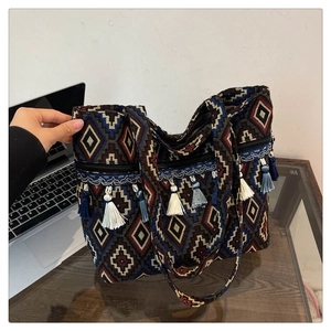 Macro view of geometric jacquard fabric and colorful long tassels on ethnic tote bag