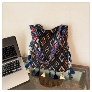 Detail of bohemian tote bag featuring colorful geometric patterns and long side tassels