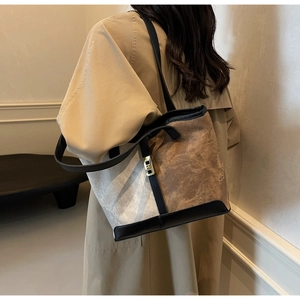 Detail of contrast stitching tote bag with gold twist lock and dual leather straps