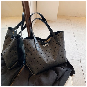 Detailed macro view of gray polka dot tote bag with metal bow and fabric texture