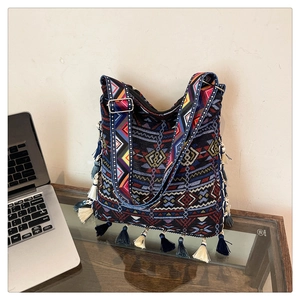 Detail of Bohemian tote bag with geometric patterns and long decorative tassels on the sides