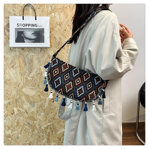 Detail of bohemian jacquard half-moon bag with blue and white fringe tassels and strap
