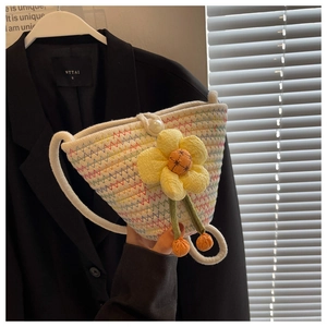 Detail of hand-woven white crossbody bag with colorful zigzag stitching and a yellow flower