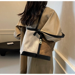 Detail view of large color-block tote bag on model showing size and matte texture