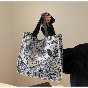 Detail of knit tote bag with black and white retro floral and butterfly patterns