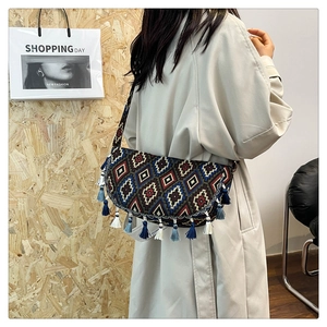 Detail of bohemian woven crossbody bag with geometric patterns and fringe tassels