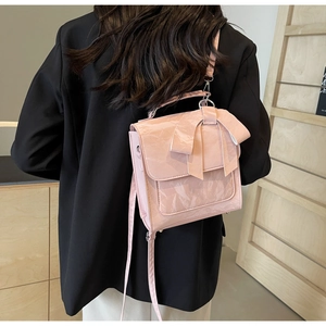 Close-up of pink patent leather bag with large bow detail and crinkled texture