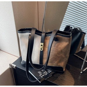 Detail of color-block tote bag with grey and brown panels and golden square buckle