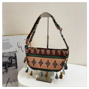 Close-up of ethnic woven crossbody bag featuring colorful tassels and geometric patterns