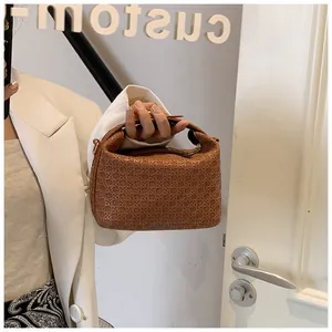 Detail of brown woven texture and metallic rings on the stylish shoulder handbag