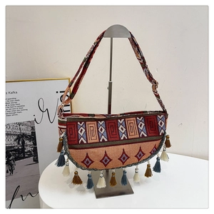 Detailed view of bohemian woven crossbody bag with colorful fringe and geometric patterns