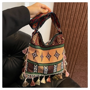 Detail of bohemian tote bag featuring ethnic jacquard weaving and colorful long fringe accents