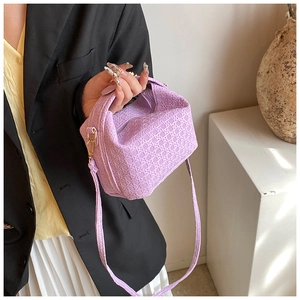 Detail of light purple woven PU leather handbag with matching shoulder strap and zipper