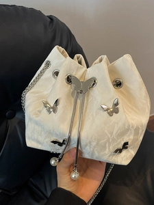 Elegant off-white bucket bag with silver butterfly charms and pearl chain strap