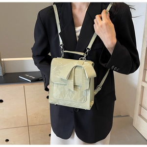 Detail of mint green bow handbag featuring pleated texture and silver metal buckles