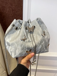 Silver metallic drawstring bucket bag with butterfly charms and pearl tassel detail