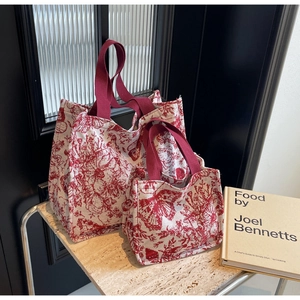 Detailed set of two canvas tote bags with classic red floral pattern and red handles