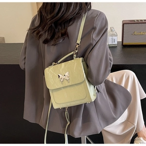 Gros plan sur le sac vert menthe à texture marbrée et fermoir papillon porté épaule