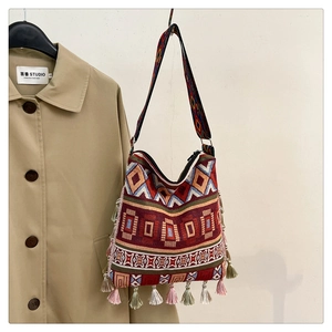 Detail of bohemian woven tote bag with colorful tassels and geometric tribal patterns
